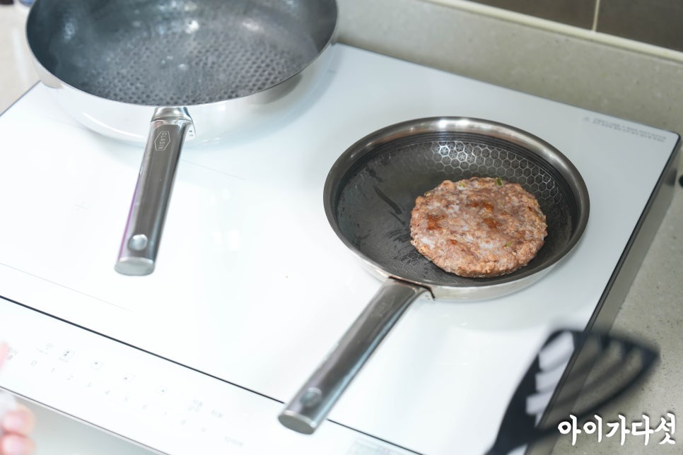 LG 디오스 오브제컬렉션 인덕션 위에서 요리를 하고 있는 모습. 한쪽 팬에는 끓는 물이 담겨 있고, 다른 팬에서는 떡갈비가 구워지고 있다.